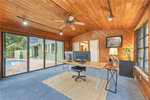 Flex space with cedar walls and ceiling with sliders to pool patio.