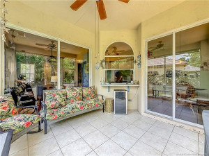 PASS THROUGH FROM KITCHEN TO SCREENED PATIO WITH FAN AND ALL TILED. THE SLIDER TO THE RIGHT IS THE KITCHEN AREA AND THE ONE TO THE LEFT IS THE LIVING AREA AND DINING. VERY PRIVE IN BACK WITH A EXTENDED PAVER PATIO OUTSIDE FOR THE GRILL AND SITTING AREA.