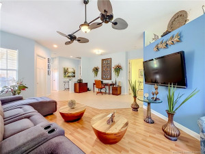 NICE LARGE LIVINGROOM OF THE DININGROOM AREA AND KITCHEN WITH SLIDERS OUT TO THE PATIO. LOOK AT THE BEAUTIFUL FAN