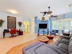 OPEN CONCEPT WITH DININGROOM AREA AND SLIDERS OUT TO THE SCREENED PATIO WITH PASS THROUGH AND A SLIDER INTO THE KITCHEN AREA BEHIND THE BLUE WALL IS THE KITCHEN. LOOK AT THAT BEAUTIFUL FAN.