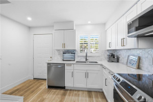Another view of the updated kitchen highlights its efficient layout, generous storage, and stainless steel appliance package.