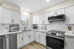 A closer view highlights abundant cabinetry and counter space, stainless steel appliances, and a window over the sink for natural light.
