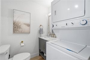 Convenient in-unit laundry is incorporated into the bathroom, with a stacked washer and dryer maximizing the available space.