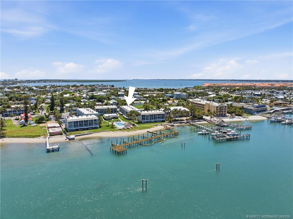 Aerial view with arrow identifying the building within the community and its close proximity to the waterfront.