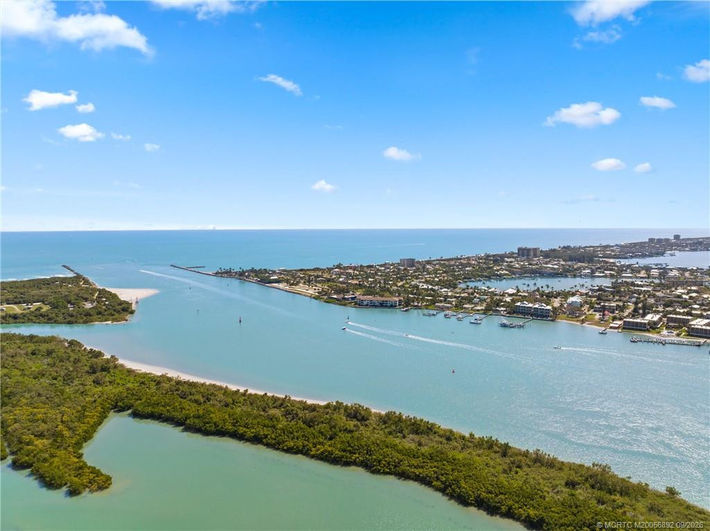Expansive aerial perspective showcases the inlet, nearby waterways, beaches, and coastal community.
