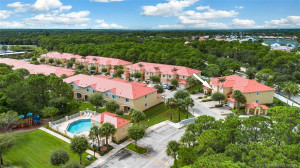 Townhouse with new metal roof is just a few steps from the community pool and is near the entrance of the community
