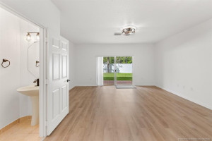 1/2 bath has new hardware and light fixture, and exhaust fan. Open floor plan leads to covered brick paver patio.