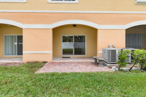 Extended open air brick paver patio with bench in addition to covered patio