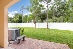 Brick paver patio nicely extends the covered patio into the grassy common area with a nice white fence