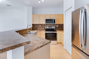 Kitchen has tile flooring, pantry, all new stainless-steel appliances, gooseneck water faucet, and filtered water faucet at stainless-steel double sink.