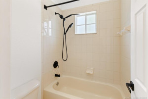 Combo tub and shower with brand new all matching plumbing fixtures, shower curtain bar, and door handle.