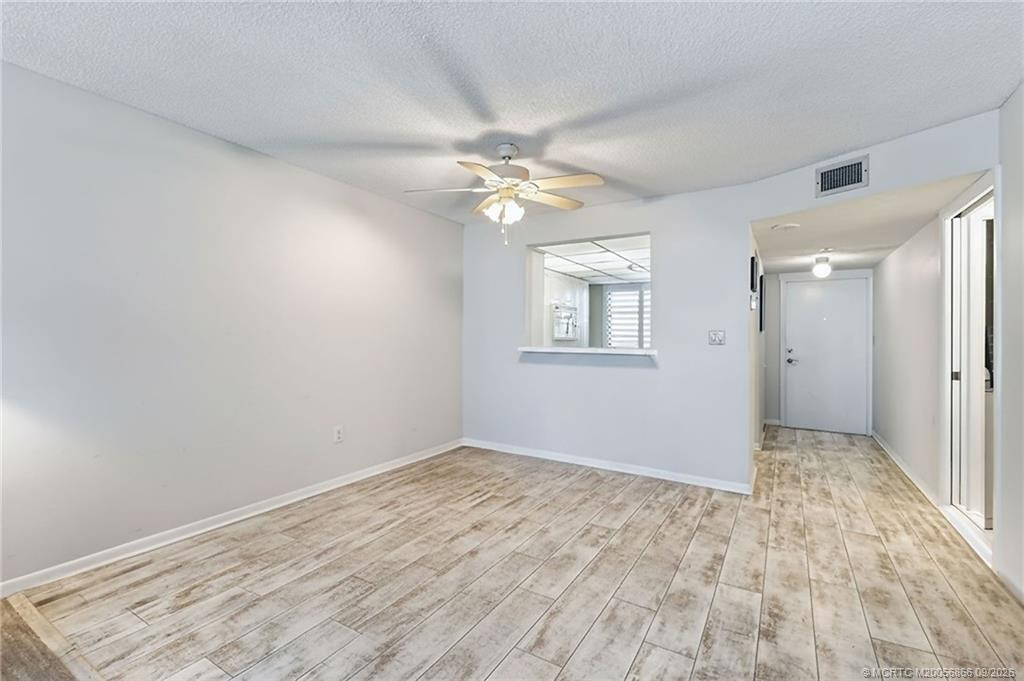 Unfurnished dining area showcasing the open layout, tile flooring and kitchen pass-through.