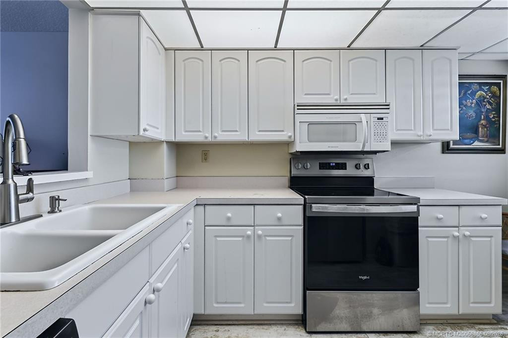 Kitchen with stainless steel appliances, plentiful storage and plantation shutters.