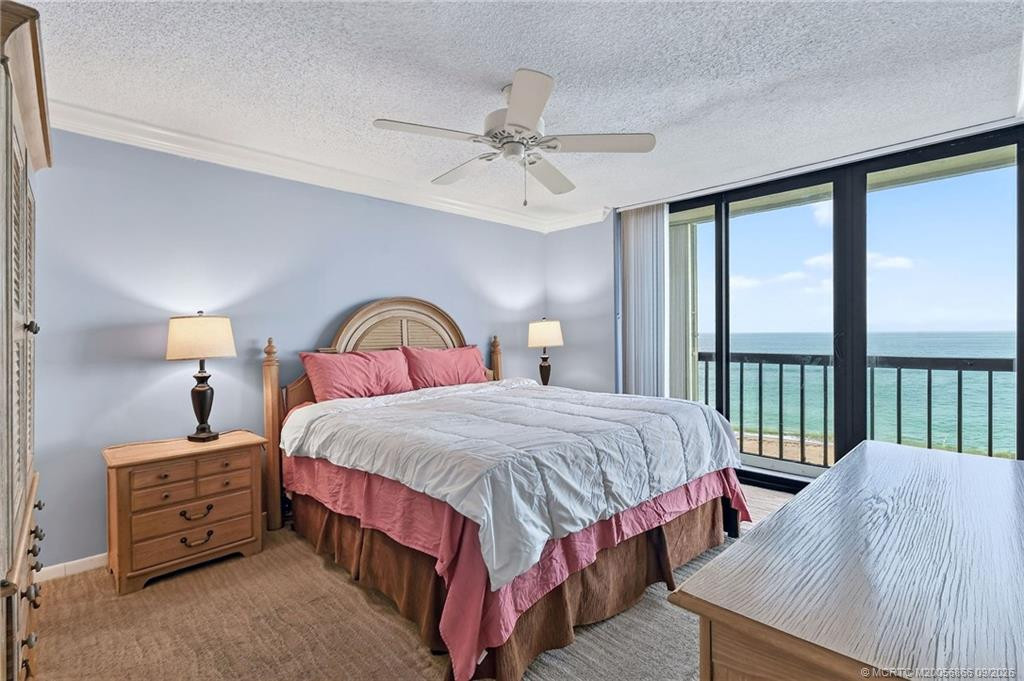 Oceanfront primary bedroom with sliding glass doors showcasing direct Atlantic Ocean views and balcony access.