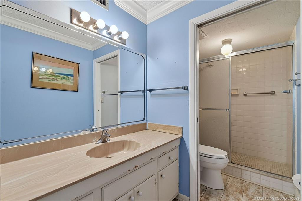 Primary bathroom with large vanity, oversized mirror and walk-in shower.