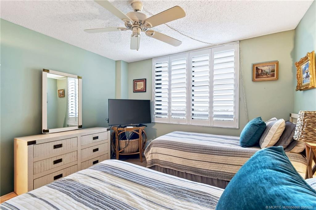 Additional view of the guest bedroom with plantation shutters and ample space for visiting family and friends.