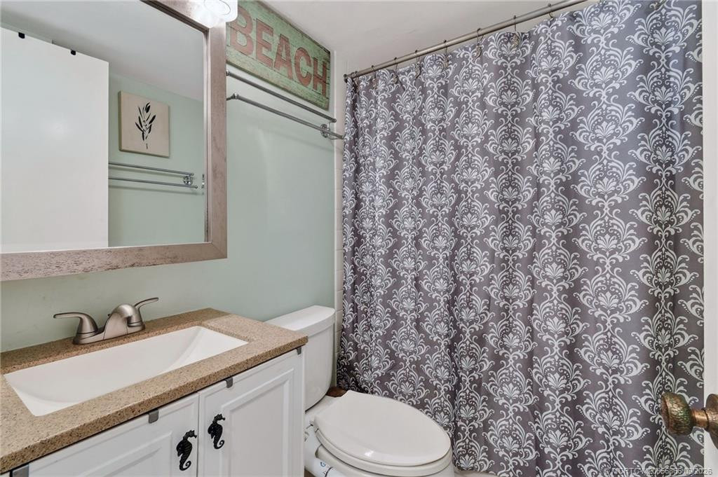 Guest bathroom with updated vanity, stone-look countertop and tub/shower combination.