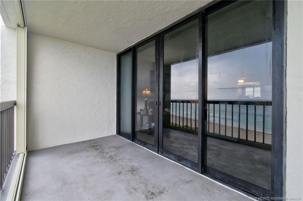 Spacious covered oceanfront balcony with sliding glass doors providing access to the interior.