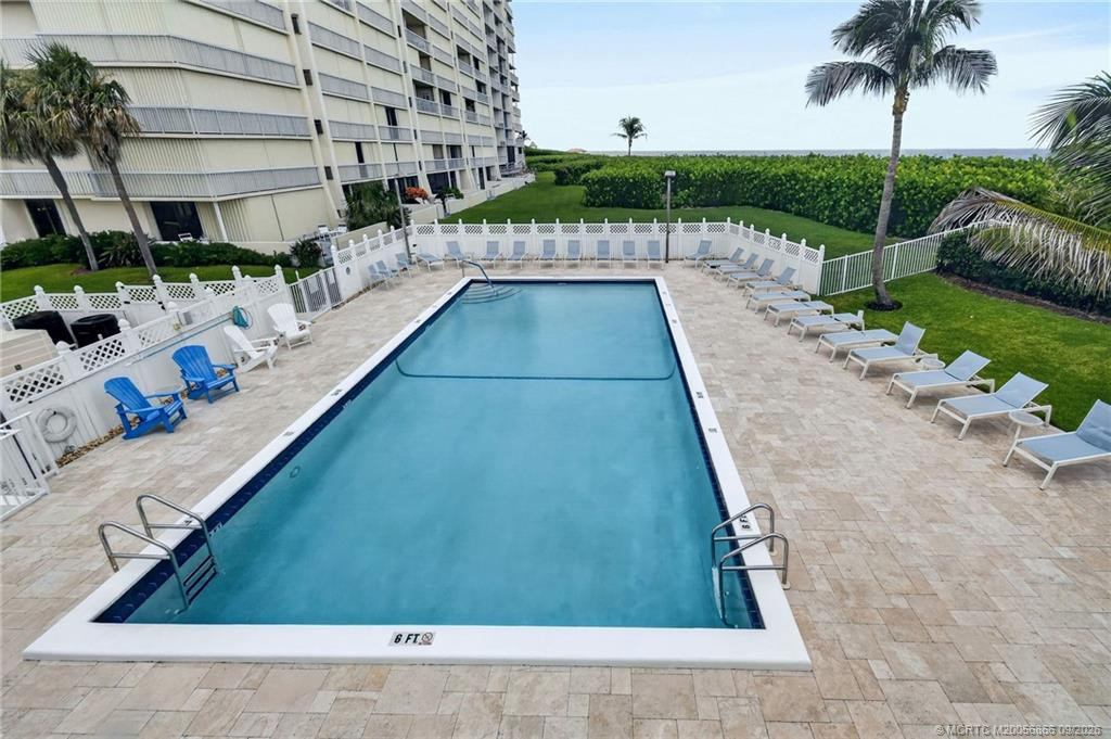 Community swimming pool with spacious deck and lounge seating.