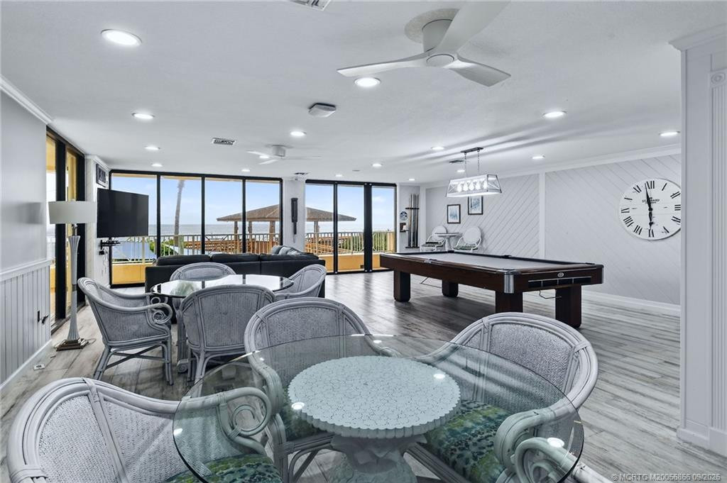 Oceanfront community game room with billiards, multiple seating areas and expansive windows overlooking the Atlantic.
