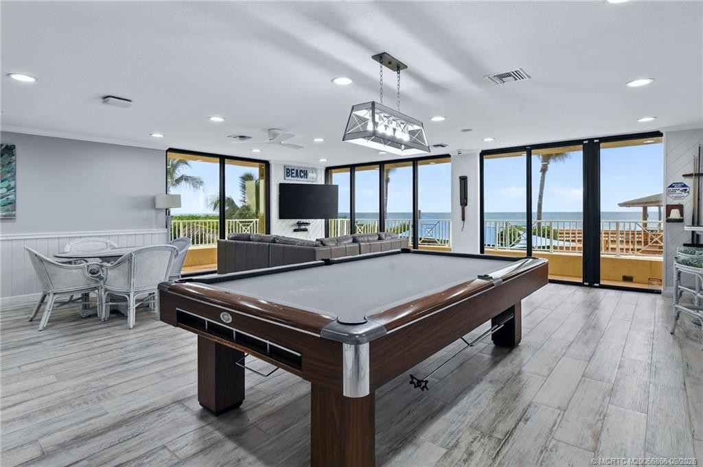 Billiards area with floor-to-ceiling windows and ocean views.