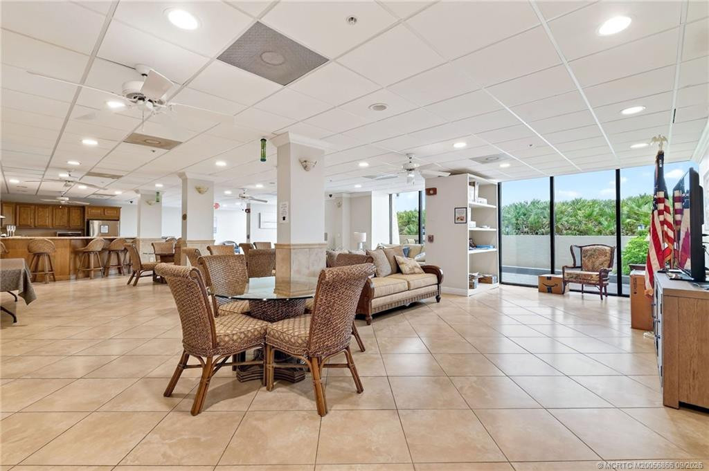 Community social room with multiple seating areas, kitchen and bar.