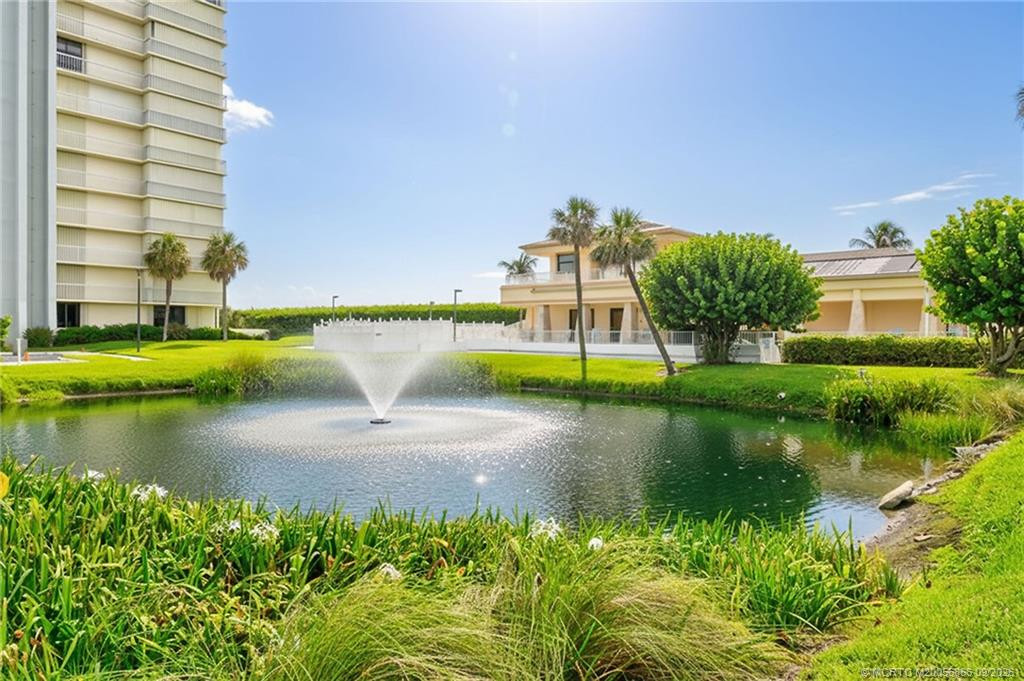 Landscaped community grounds with a tranquil pond and fountain.