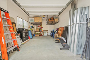 Secondary garage with overhead racks provide ample space