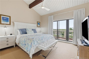 Spacious guest suite features a vaulted ceiling, private balcony access and peaceful views over the surrounding tropical landscape.