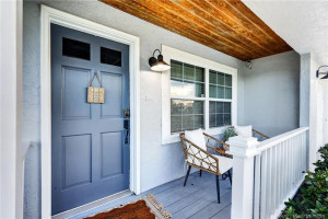 Greet your guests from this welcoming front porch with warm wood ceiling.