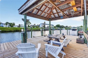 Unwind waterside beneath the shaded tiki-style gathering area, perfect for enjoying peaceful canal views.
