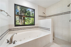 Jetted tub and walk in shower with shower heads on both walls.