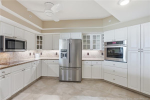 Spacious kitchen featuring white cabinetry, granite countertops, stainless-steel appliances, and abundant storage.
