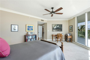 Generously sized primary suite with a dedicated workspace and direct access to the oceanfront balcony.