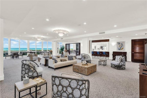 Beautifully furnished community social room featuring spacious seating areas, coastal décor, and expansive windows overlooking the Atlantic Ocean.