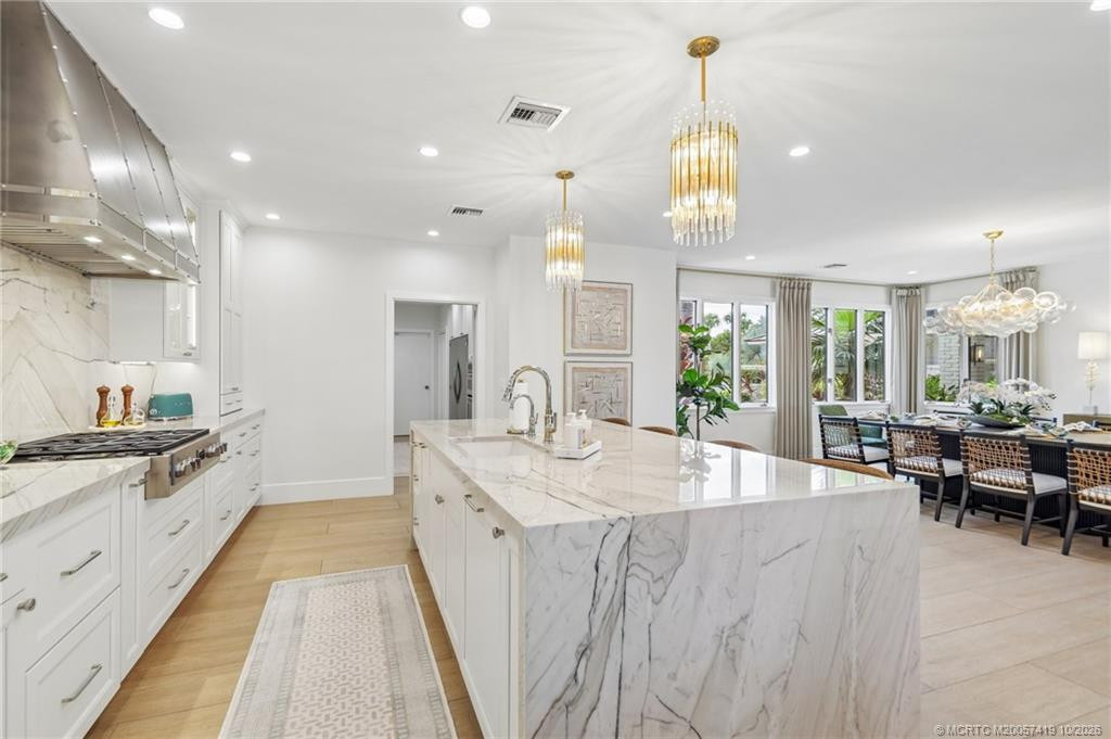 a spectacular waterfall quartzite island, designer lighting, and premium finishes.