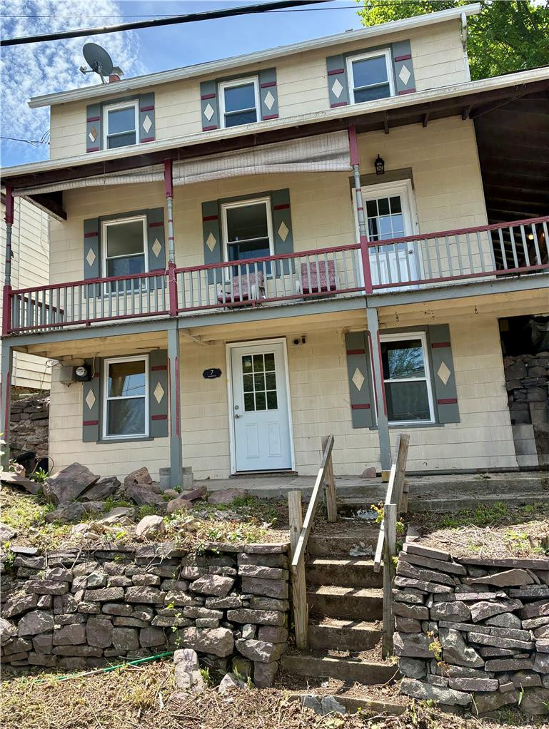 A charming multi-story residence with a welcoming front porch and decorative shutters awaits. A charming multi-story residence with a welcoming