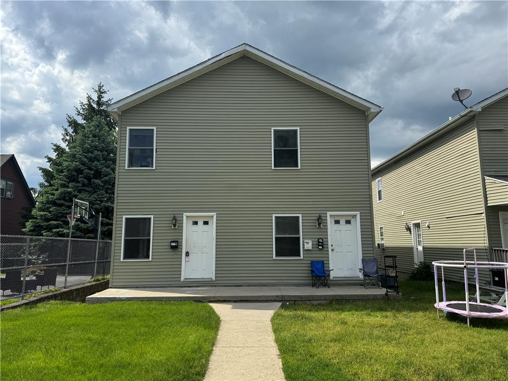 Clean lines and a manicured lawn frame this multi-family exterior with dual private entrances. Clean lines and a manicured lawn frame this multi-