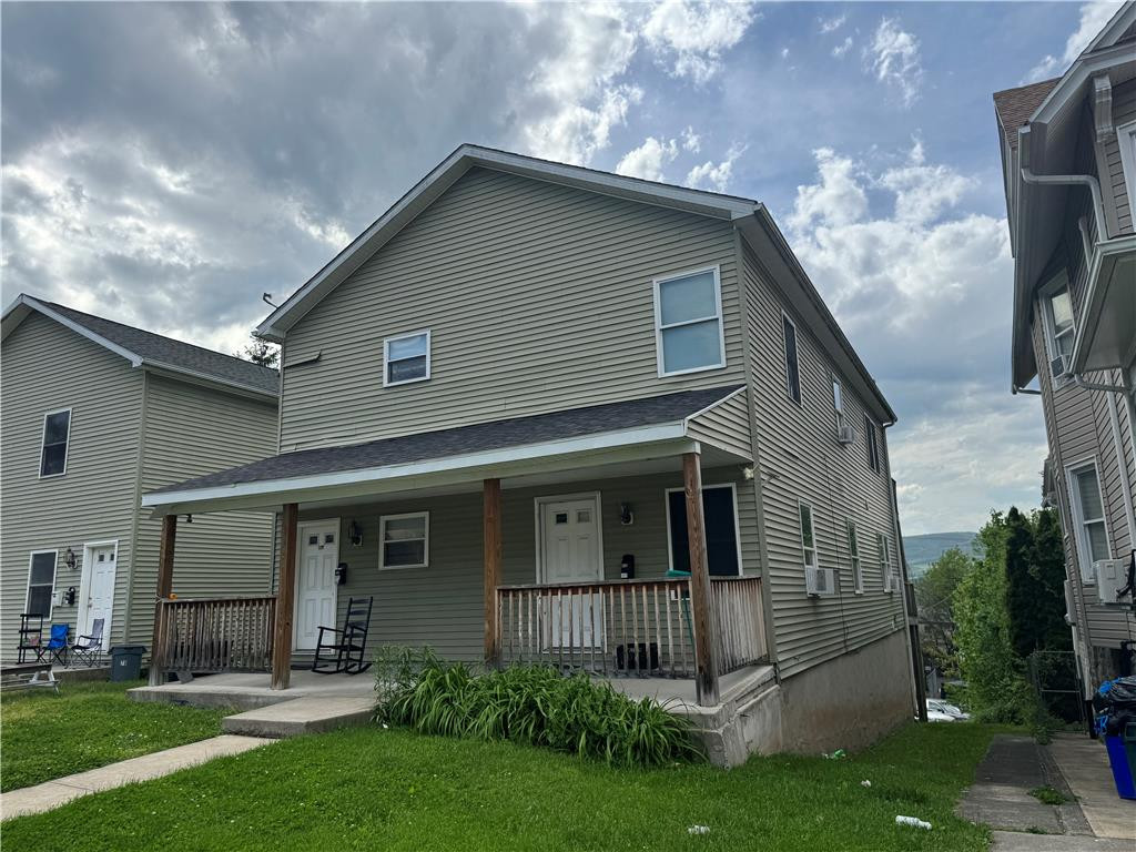 Classic siding exterior frames this multi-level residential structure featuring a covered front porch. Classic siding exterior frames this multi-level re