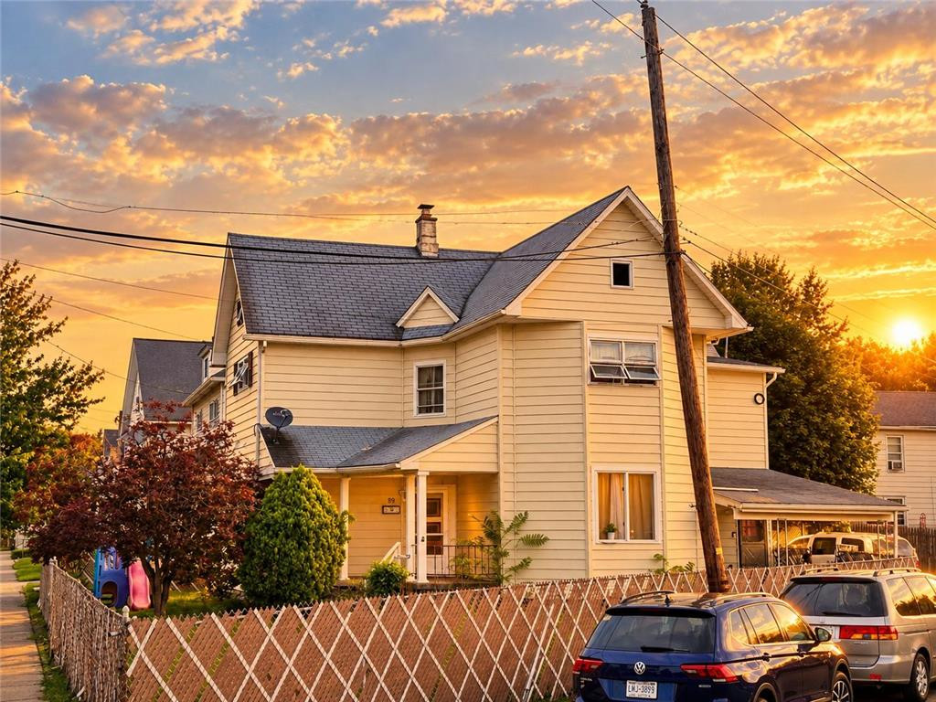 Classic siding and architectural details define this multi-story residence at sunset. Classic siding and architectural details define th