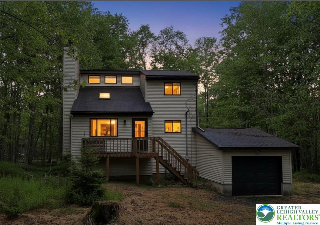 A tranquil woodland retreat, this home glows warmly at dusk, offering a serene escape. A tranquil woodland retreat, this home glows warml