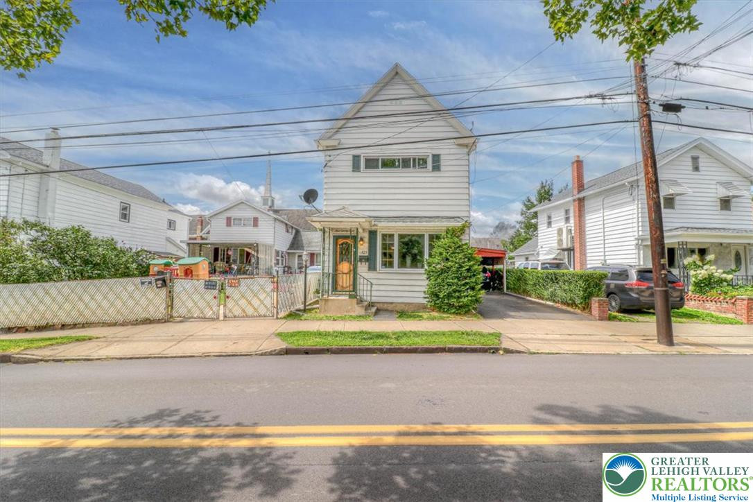 Classic vinyl siding and a tidy front porch define this charming multi-level residence. Classic vinyl siding and a tidy front porch define
