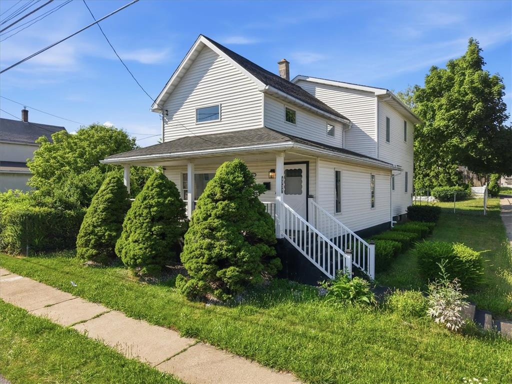 Classic siding, a welcoming front porch, and mature evergreens define this multi-level home. Classic siding, a welcoming front porch, and matur