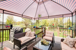 Photo for 7812 29th Street N, Oakdale, MN 55128 - Listing #6193596 View of the deck coming off the dining area on the upper level, with this great overhang canopy that stays with the home. Super nice on a sunny afternoon, and great view of this super backyard.