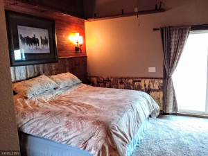 Photo for 90917 240th Street, Austin, MN 55912 - Listing #6176986 Guest room with barn wood finishes patio doors open to a huge concrete patio where the whirlpool is located as well.