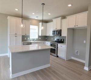 Photo for 13205 Deerwood Lane N, Dayton, MN 55327 - Listing #6097796 The centerpiece of the space is the island - which has cabinet storage and a recycling center on one side, and an overhang for seating/dining on the other! (Photo of same plan, colors are similar)