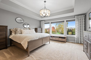 Photo for 11610 Aster Lane, Woodbury, MN 55129 - Listing #6114865 The owners suite features a stylish chandelier nestled in a coffered ceiling, a wall of windows that fill the room with natural light and plenty of space.