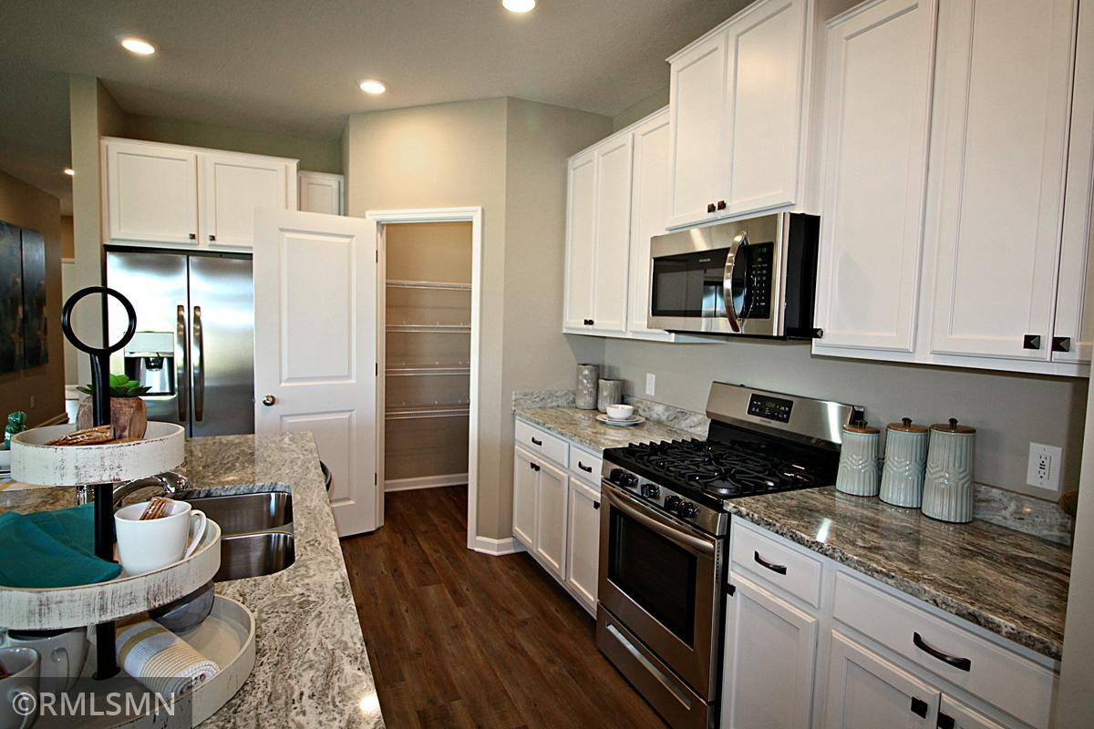 Photo for 373 Freedom Lane, Delano, MN 55328 - Listing #6127482 In addition to all of the cabinet and counter space, there is also plenty of room for the chef to maneuver as that next meal is prepared! And check out the convenient entrance to your walk-in pantry! Photo of model, colors will vary