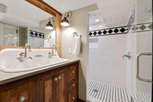 Photo for 3530 Edmund Boulevard, Minneapolis, MN 55406 - Listing #6205579 Nearby is a ceramic tiled three-quarter bath with a farmhouse sink with two faucets.