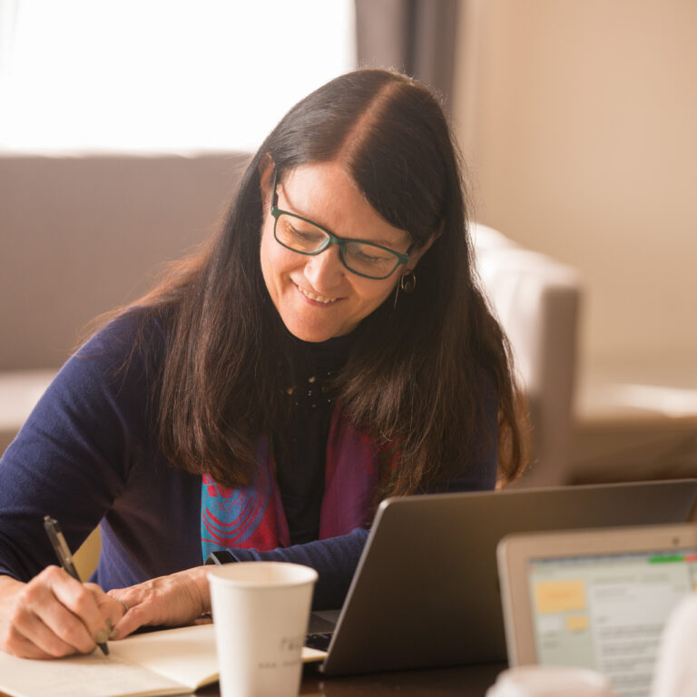 Learner writing notes during a personalized Fluenz Live Online Spanish session via Zoom, supported by structured coaching and interactive tools.